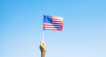 A person holding American flag symbolizing successful immigration journey and achievement.
