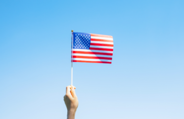 A person holding American flag symbolizing successful immigration journey and achievement.